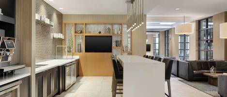 A modern kitchen with a central island, built-in appliances, and a large flat-screen TV.