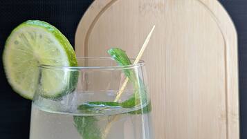 Ett genomskinligt glas med en limeskiva och mynta, placerat på en träyta. I bakgrunden syns en skärbräda med ordet ”drift” skrivet på.