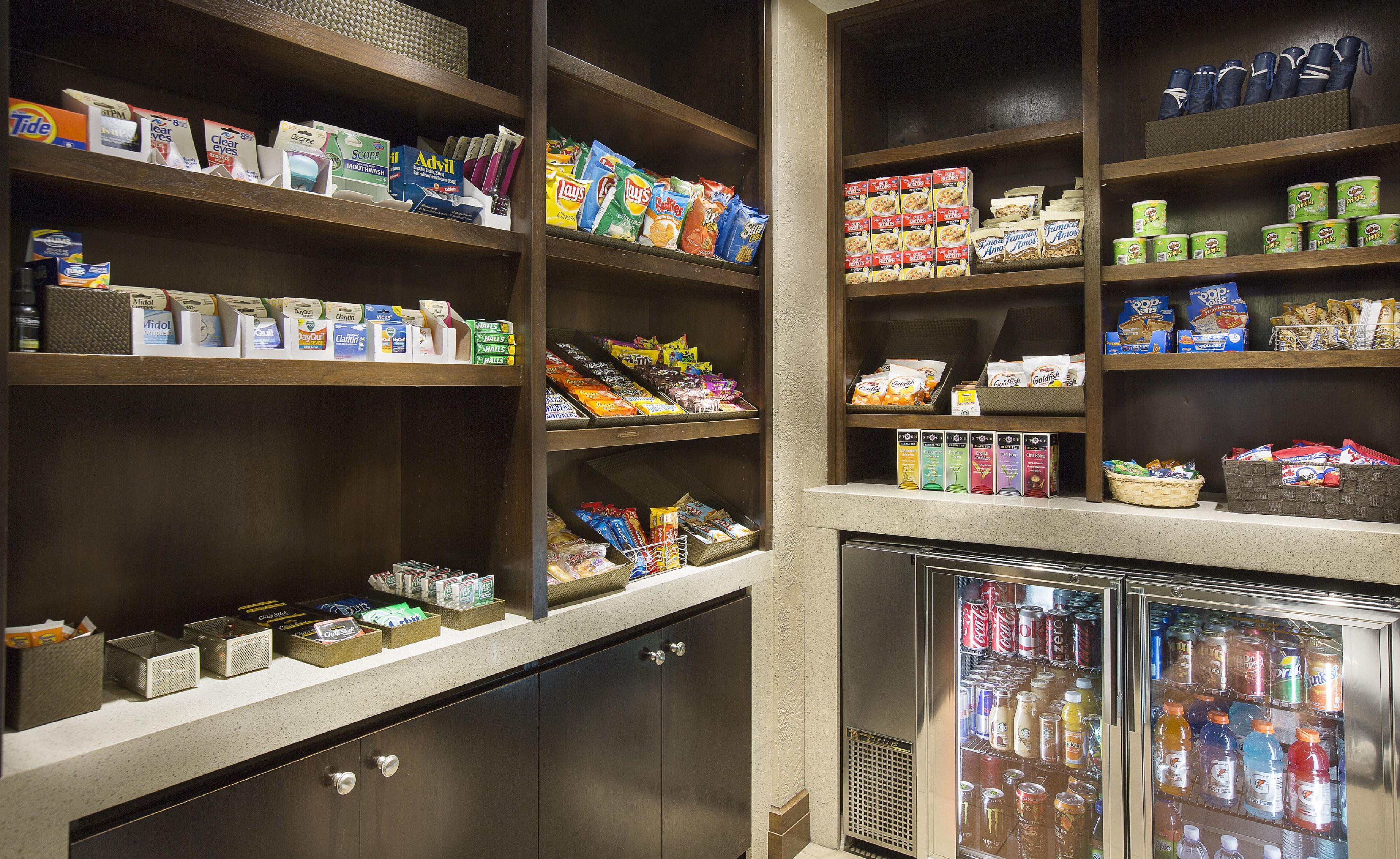 A well-stocked convenience store with shelves of snacks, beverages, and household items.