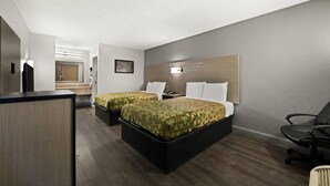Habitación de hotel con dos camas, un escritorio, una silla y un espejo grande.