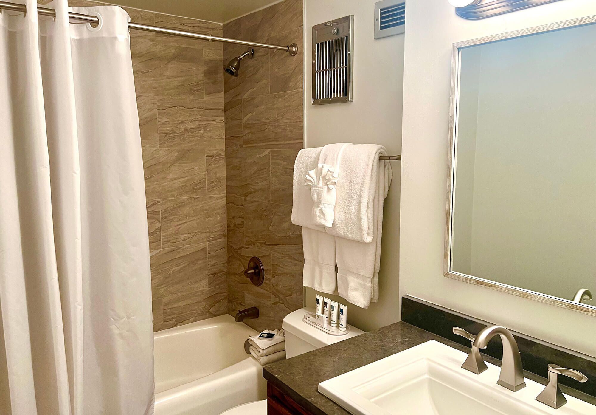 A modern bathroom with a bathtub, shower, and two sinks.