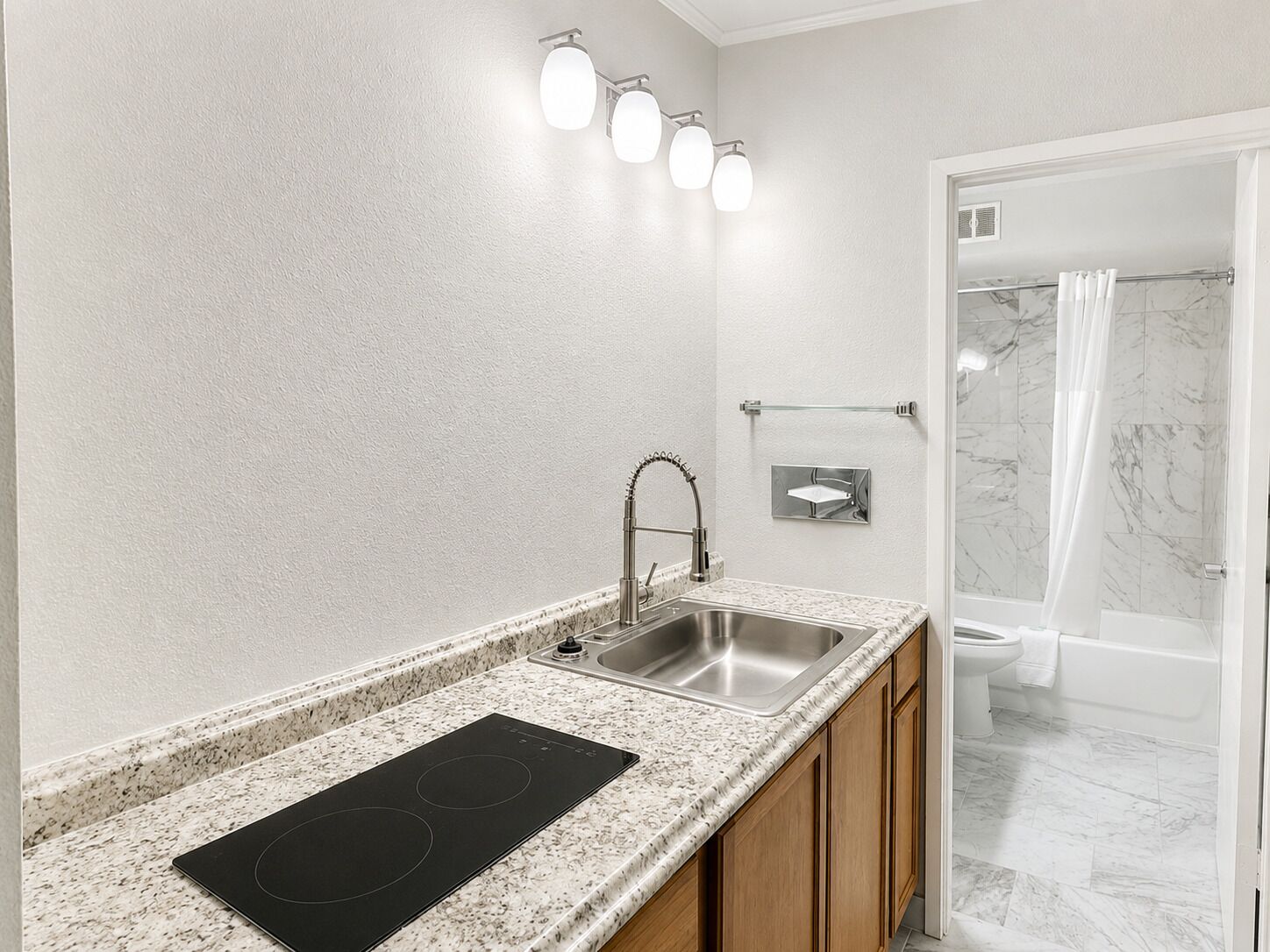 Un baño moderno con lavabo, espejo y ducha.