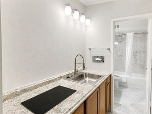 A modern bathroom with a sink, mirror, and shower.