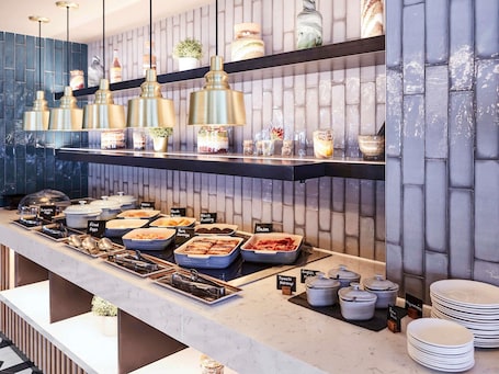 A buffet with various food options and condiments.. Novotel Birmingham Airport
