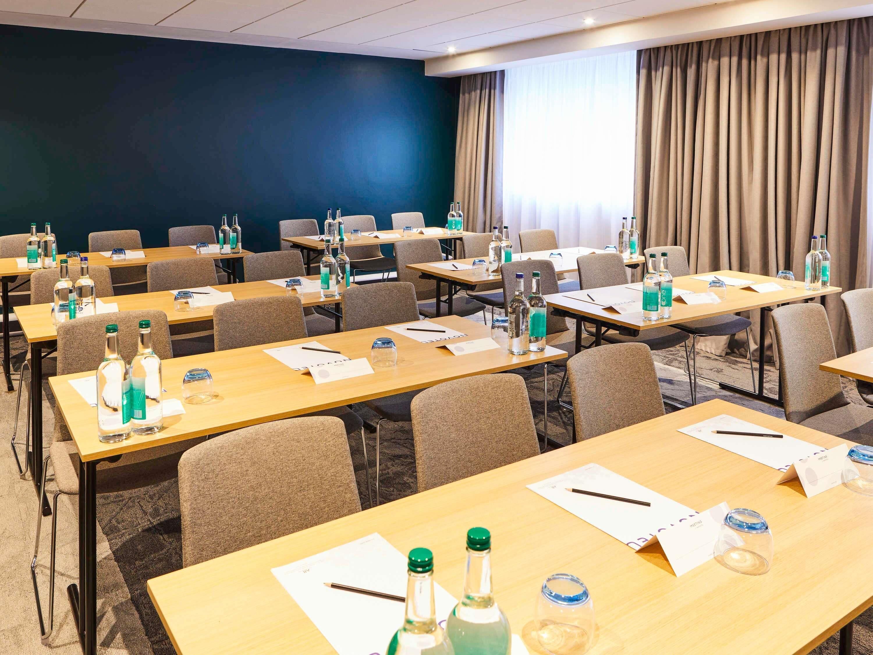 A conference room with tables, chairs, and water bottles.