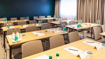 A conference room with tables, chairs, and water bottles.