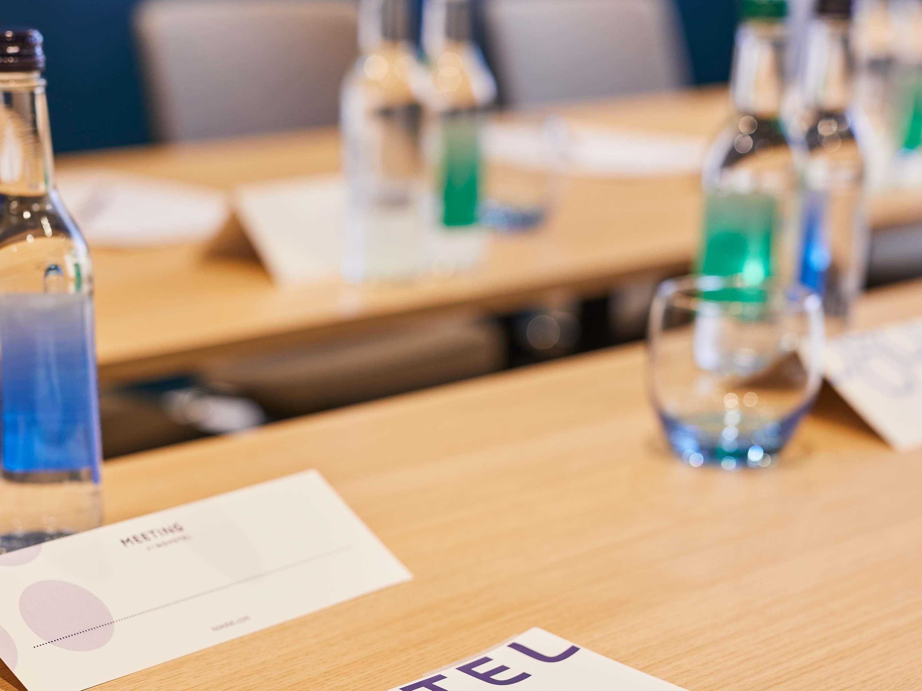 A meeting room with tables, chairs, and name cards.