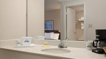 Une salle de bain d’hôtel équipée d’un lavabo, d’un miroir et d’articles de toilette.