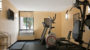 A gym with exercise equipment, a treadmill, and a wall-mounted TV. - Days Inn by Wyndham Reading Wyomissing (Wyomissing)