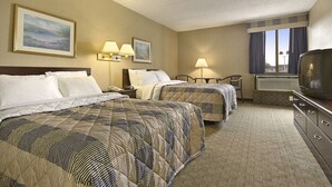 A hotel room with two beds, a TV, a desk, and a window with curtains. - Days Inn by Wyndham Reading Wyomissing (Wyomissing)