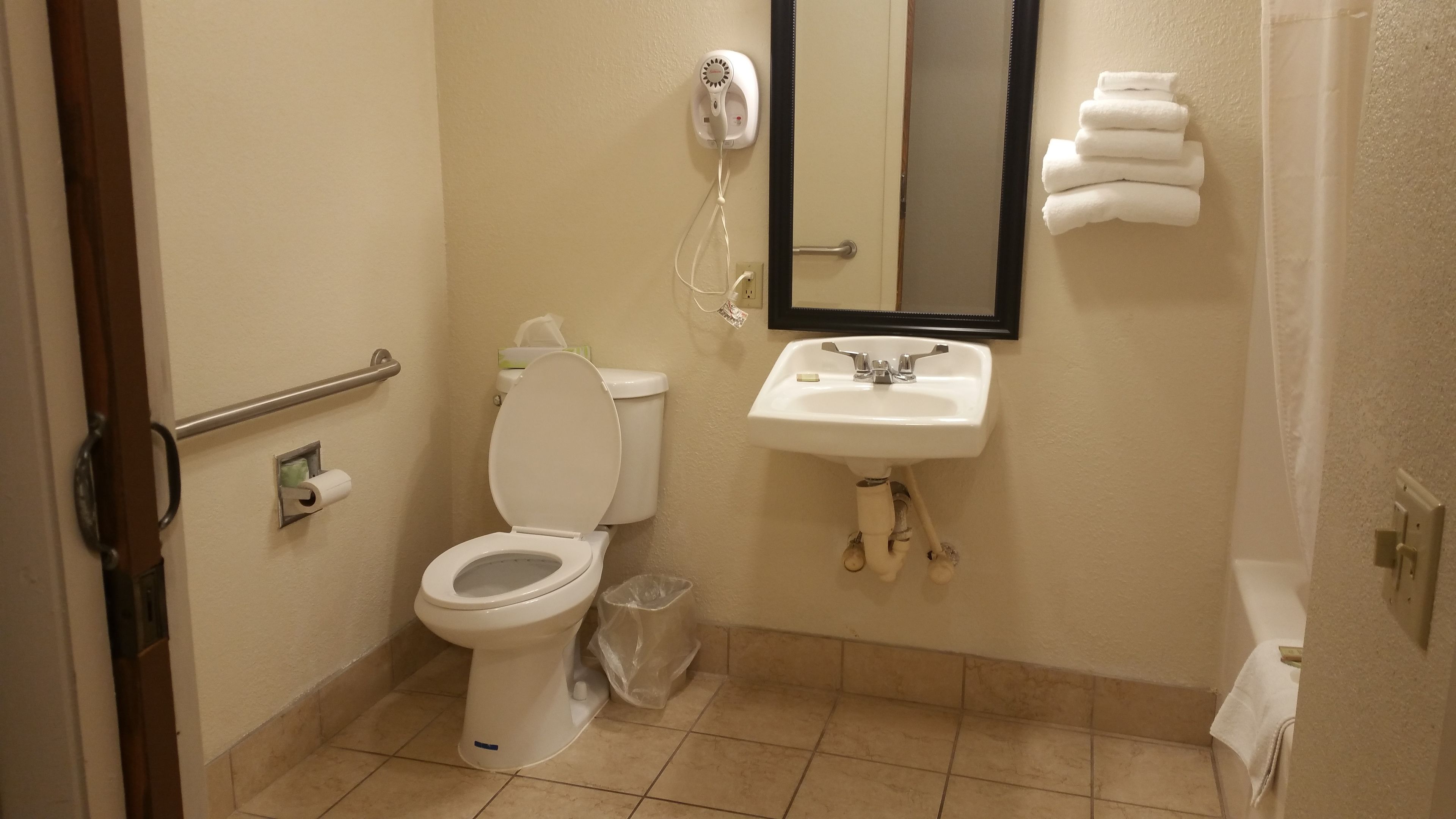 Et lille badeværelse med toilet, håndvask og hårtørrer.