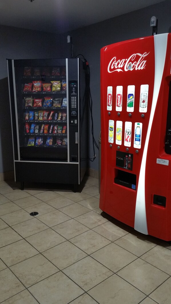 Two vending machines, one with a Coca-Cola logo and another with various snacks. - Baymont by Wyndham Tuscola (Tuscola)