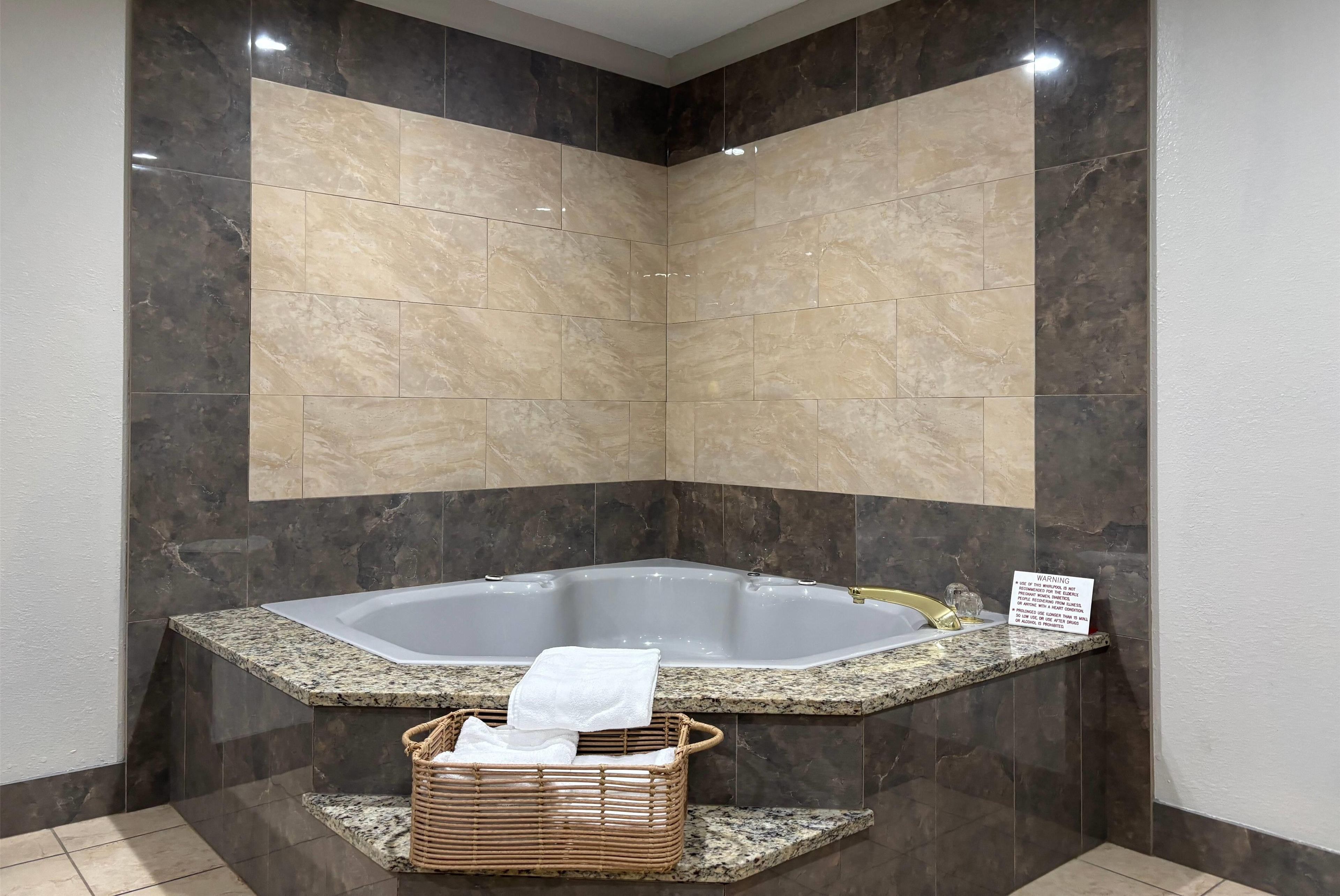 A bathroom with a freestanding bathtub, a wicker basket, and a warning sign.