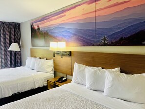A hotel room with two beds, a nightstand, a lamp, a phone, and a sunset mural on the wall. - Days Inn by Wyndham Jellico - Tennessee State Line (Jellico)
