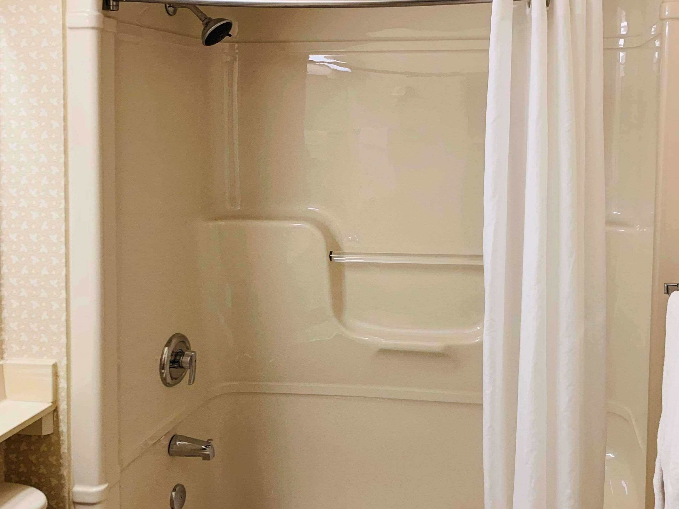 Un baño con ducha, inodoro y perchero para toallas.