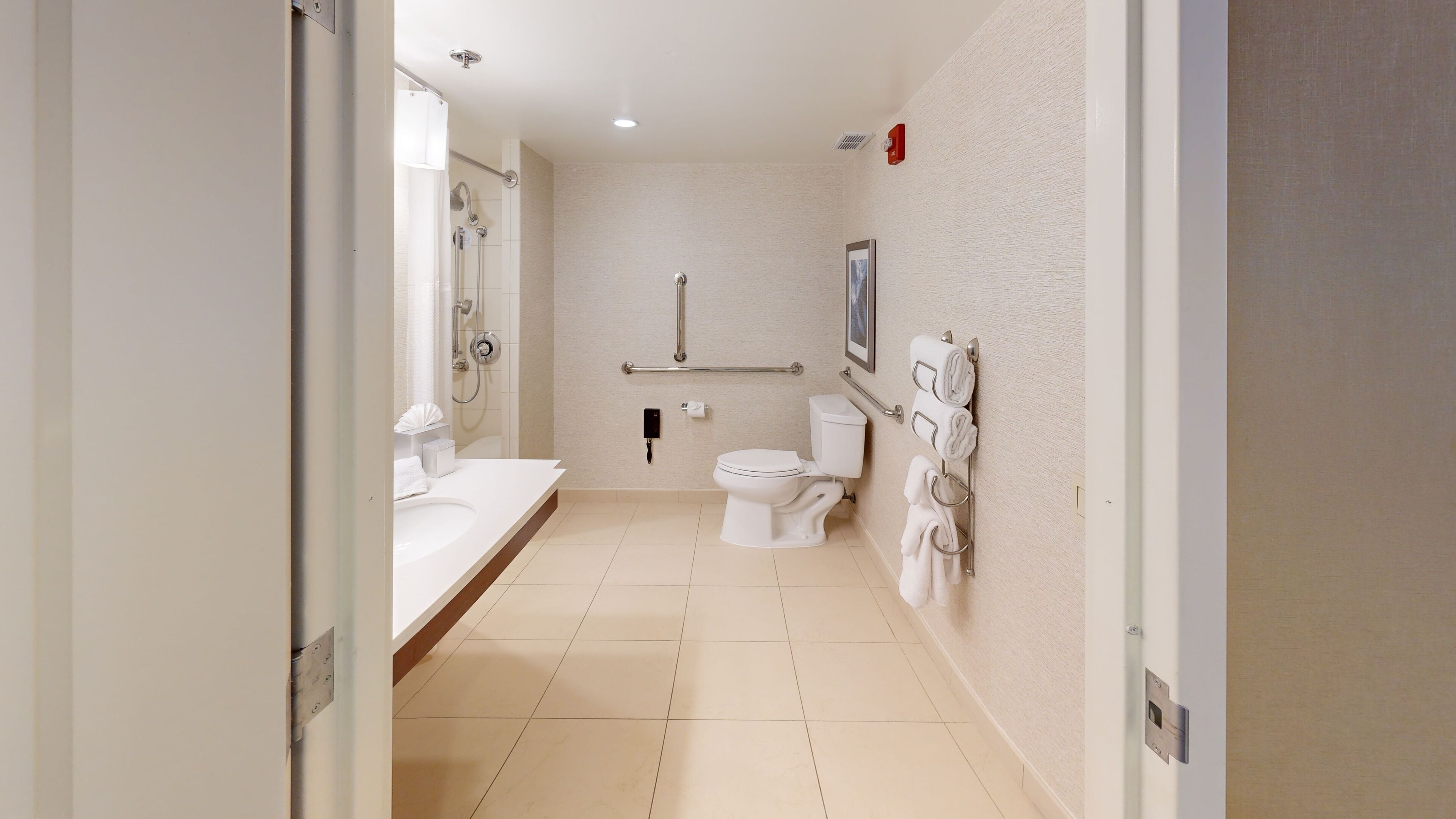 A modern bathroom with a toilet, bidet, and hand dryer.