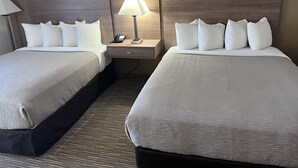 Ein Hotelzimmer mit zwei Betten, einem Nachttisch mit Lampe und einem Telefon.