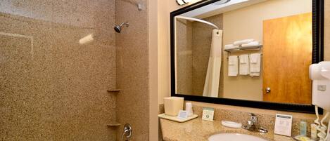 Une salle de bain avec une baignoire, un lavabo et un grand miroir.
