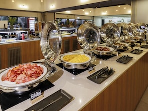 A buffet with various food items and serving utensils.