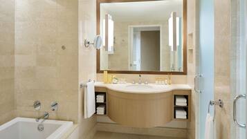 Un baño moderno con bañera, lavamanos y espejo grande.