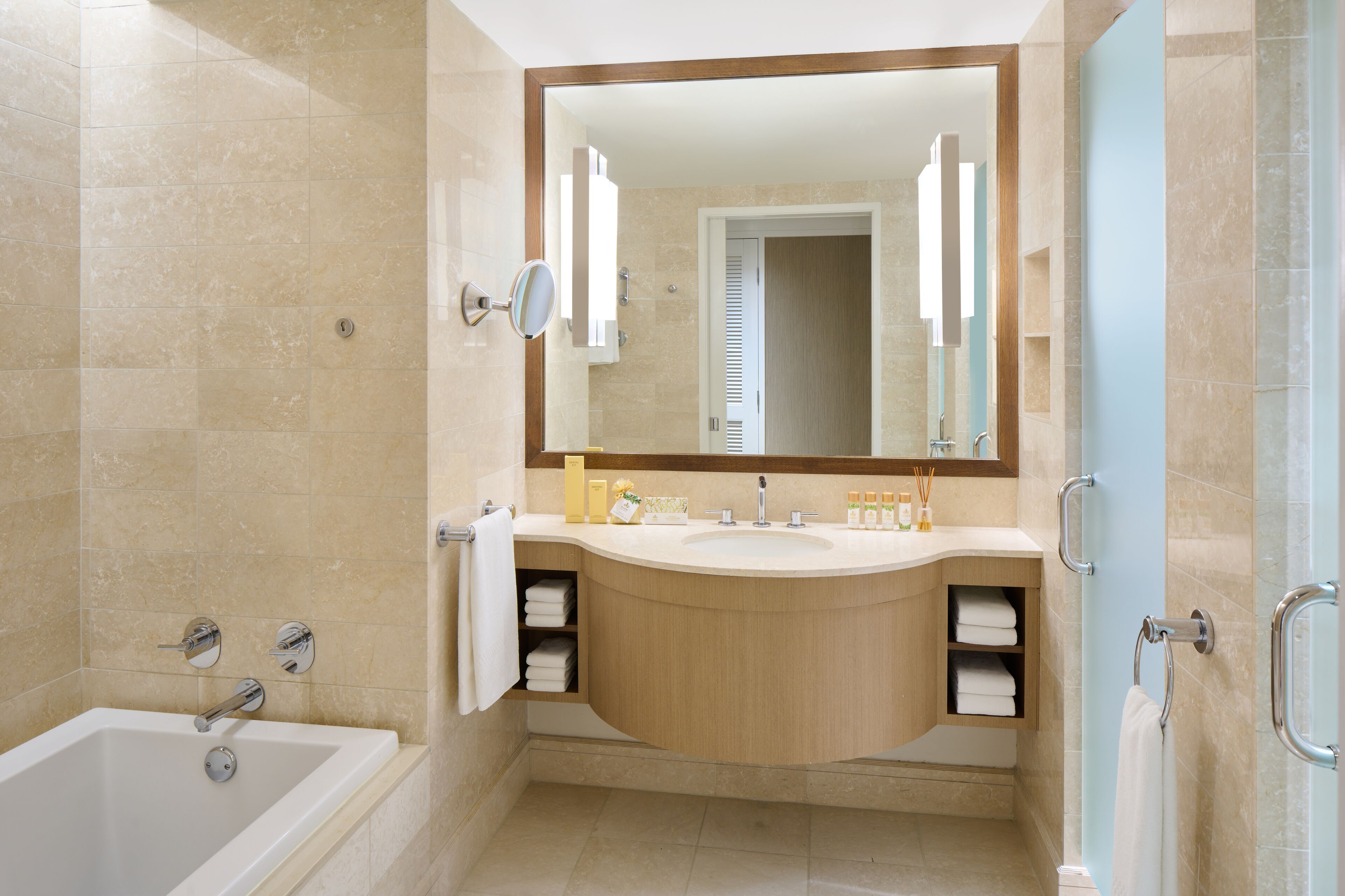 Un baño moderno con bañera, lavamanos y espejo.