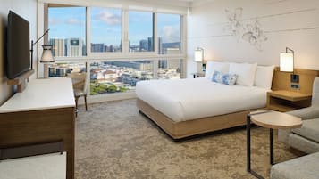 Une chambre d’hôtel avec un grand lit, un bureau, une chaise, une télévision et une vue sur le paysage urbain.