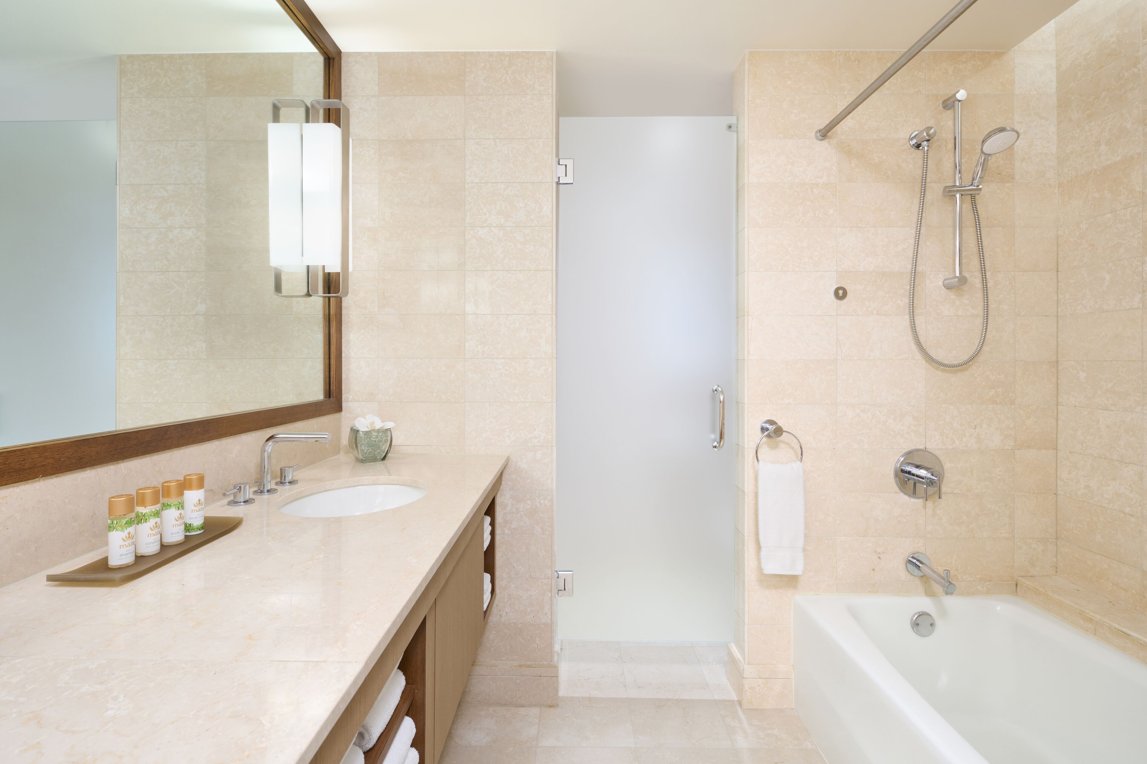 Un baño moderno con un espejo grande, dos lavamanos, una zona de ducha y una bañera.