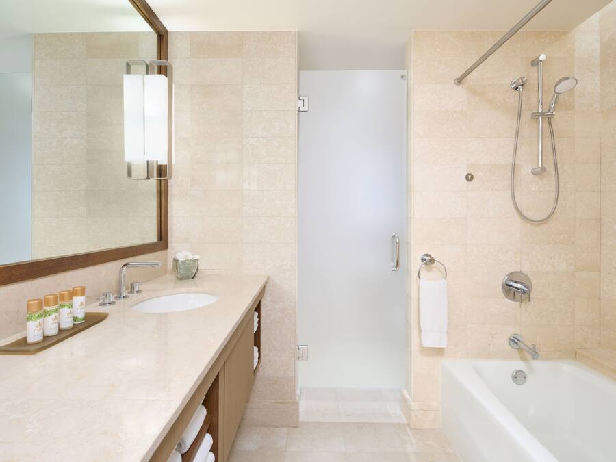 Un baño moderno con un espejo grande, dos lavamanos, una zona de ducha y una bañera.