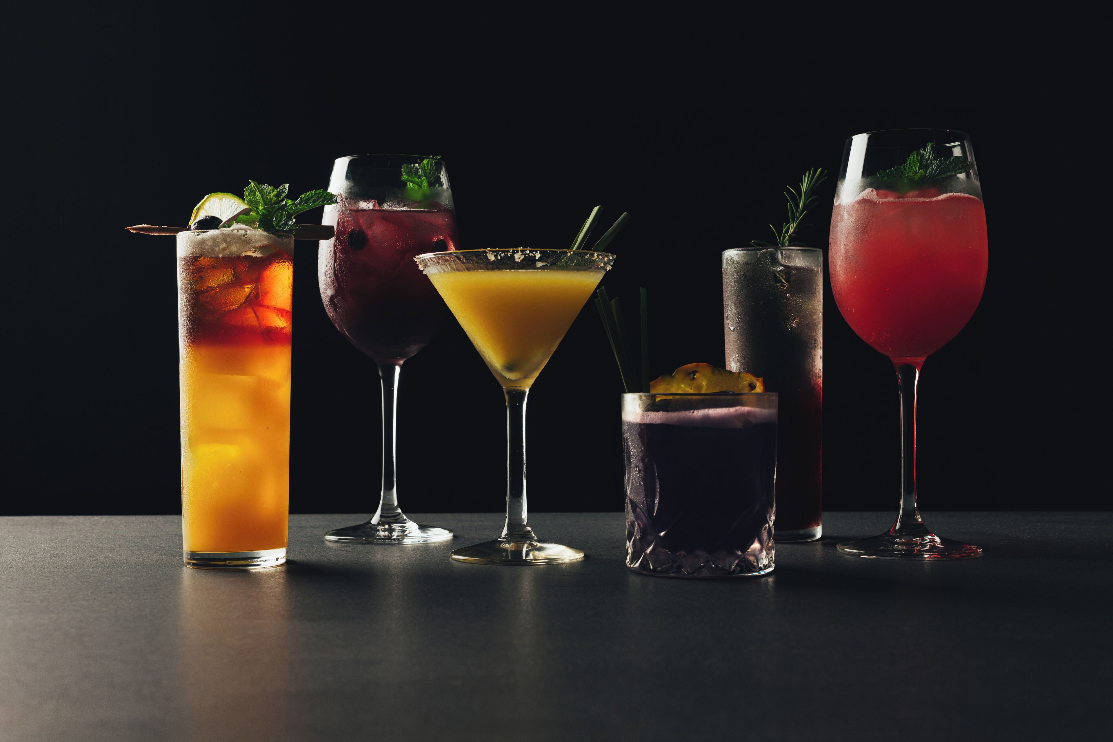 Five different cocktails in various glassware.