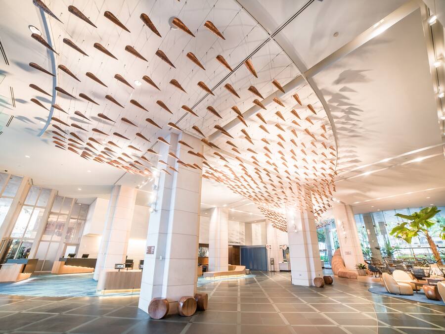 A spacious lobby with a high ceiling, modern seating areas, and a reception desk.