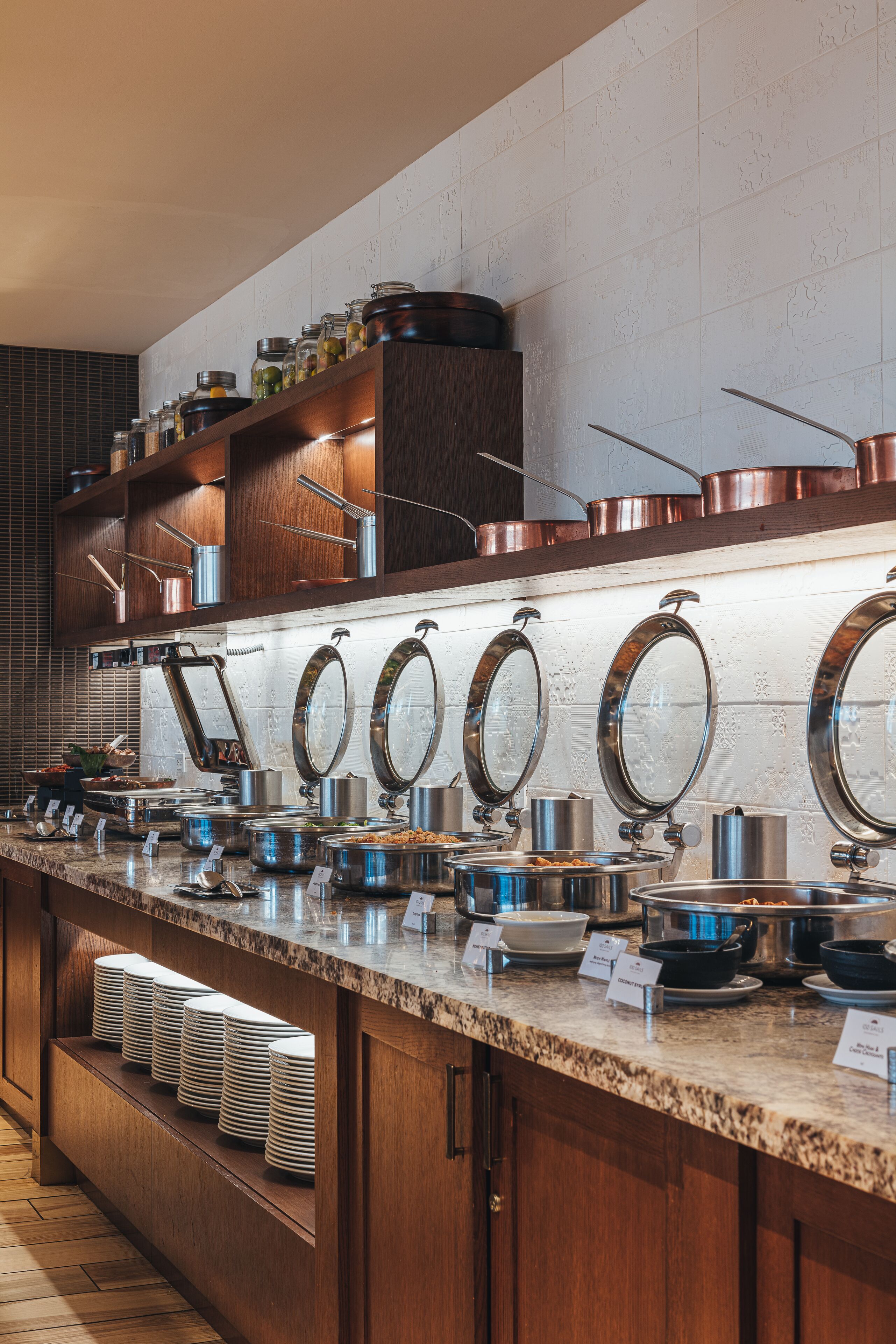 Un'attrezzatura per buffet con diverse postazioni di servizio, pentole in acciaio inossidabile e piatti ordinatamente disposti.