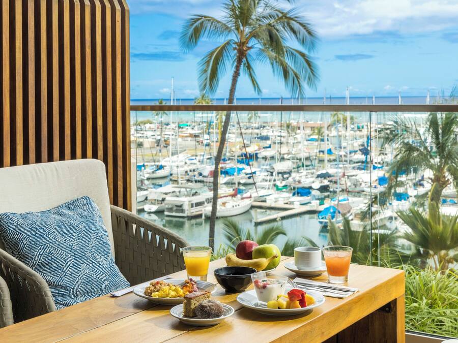 Une table à manger dressée pour le petit-déjeuner, avec vue sur un port de plaisance.