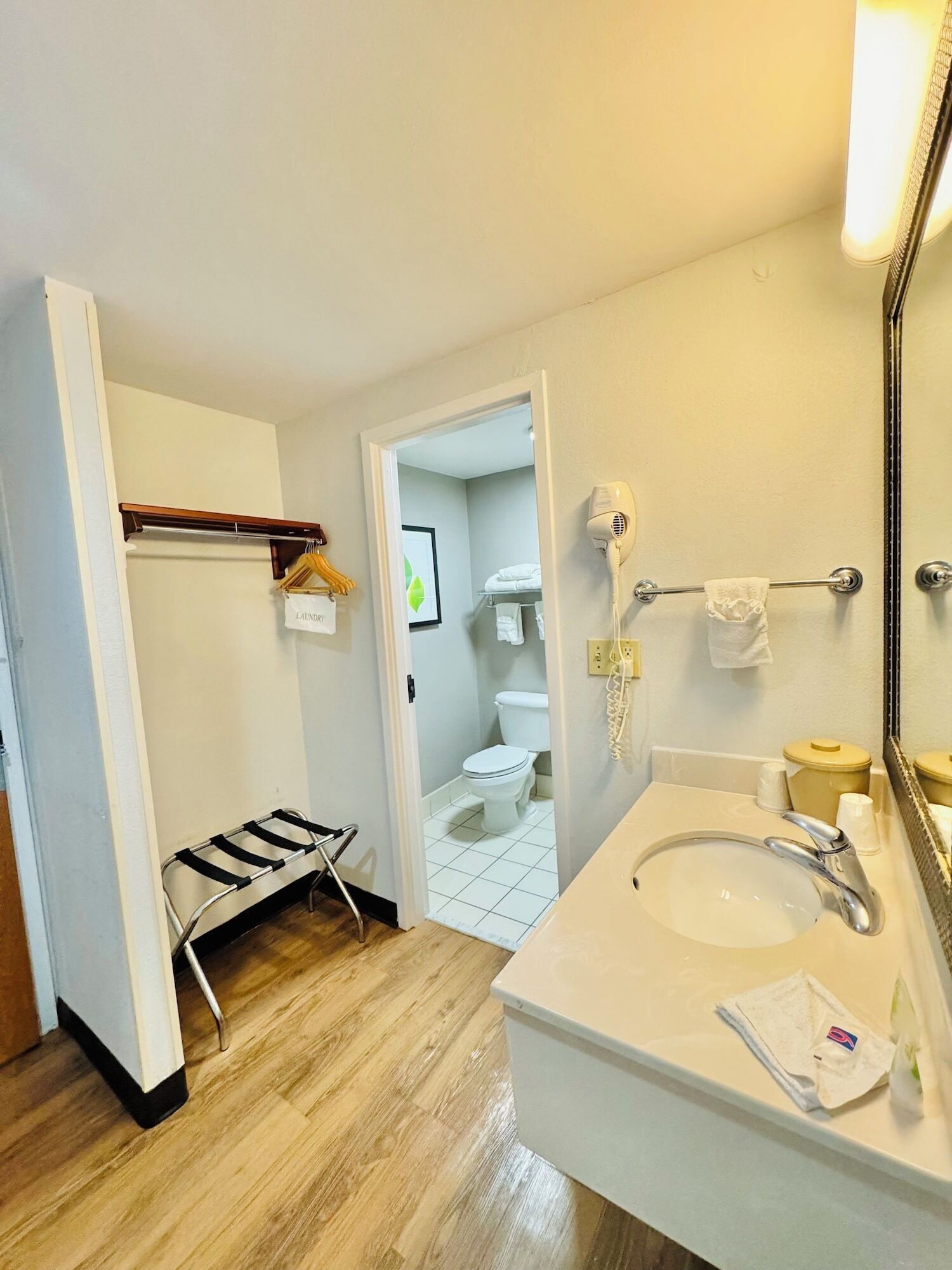 A bathroom with a sink, mirror, and towel rack.
