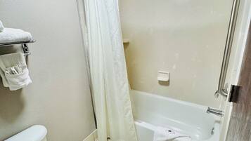 Un baño con inodoro, bañera y cortina de ducha.