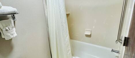Un baño con inodoro, bañera y cortina de ducha.