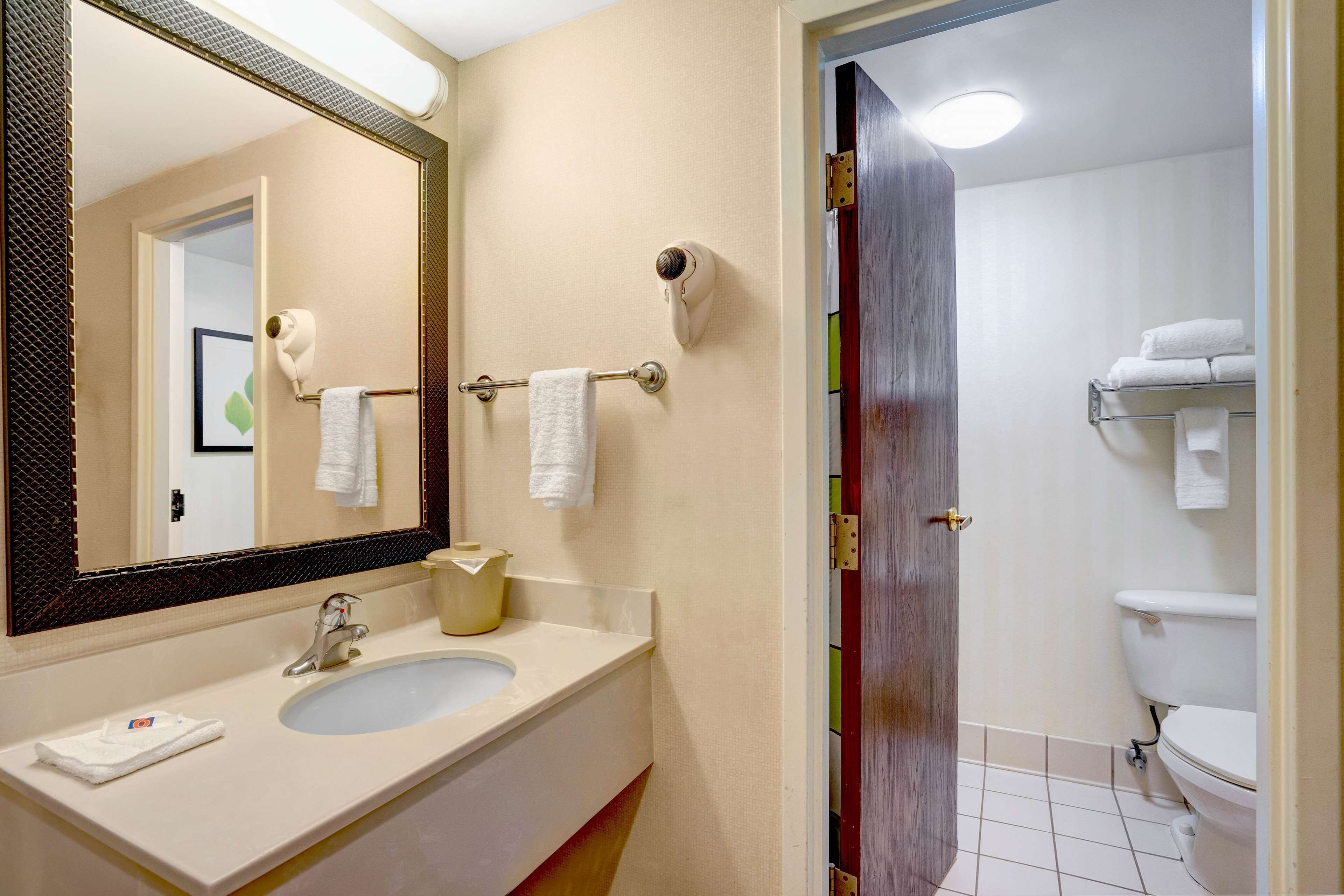 Une salle de bain équipée d’un lavabo, d’un miroir, d’un porte-serviettes et de toilettes.
