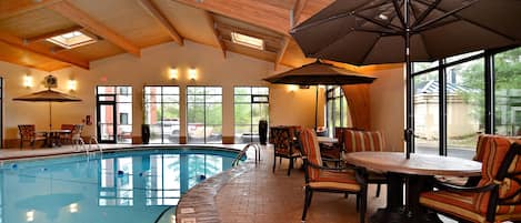 Una piscina techada, sillones reclinables de piscina