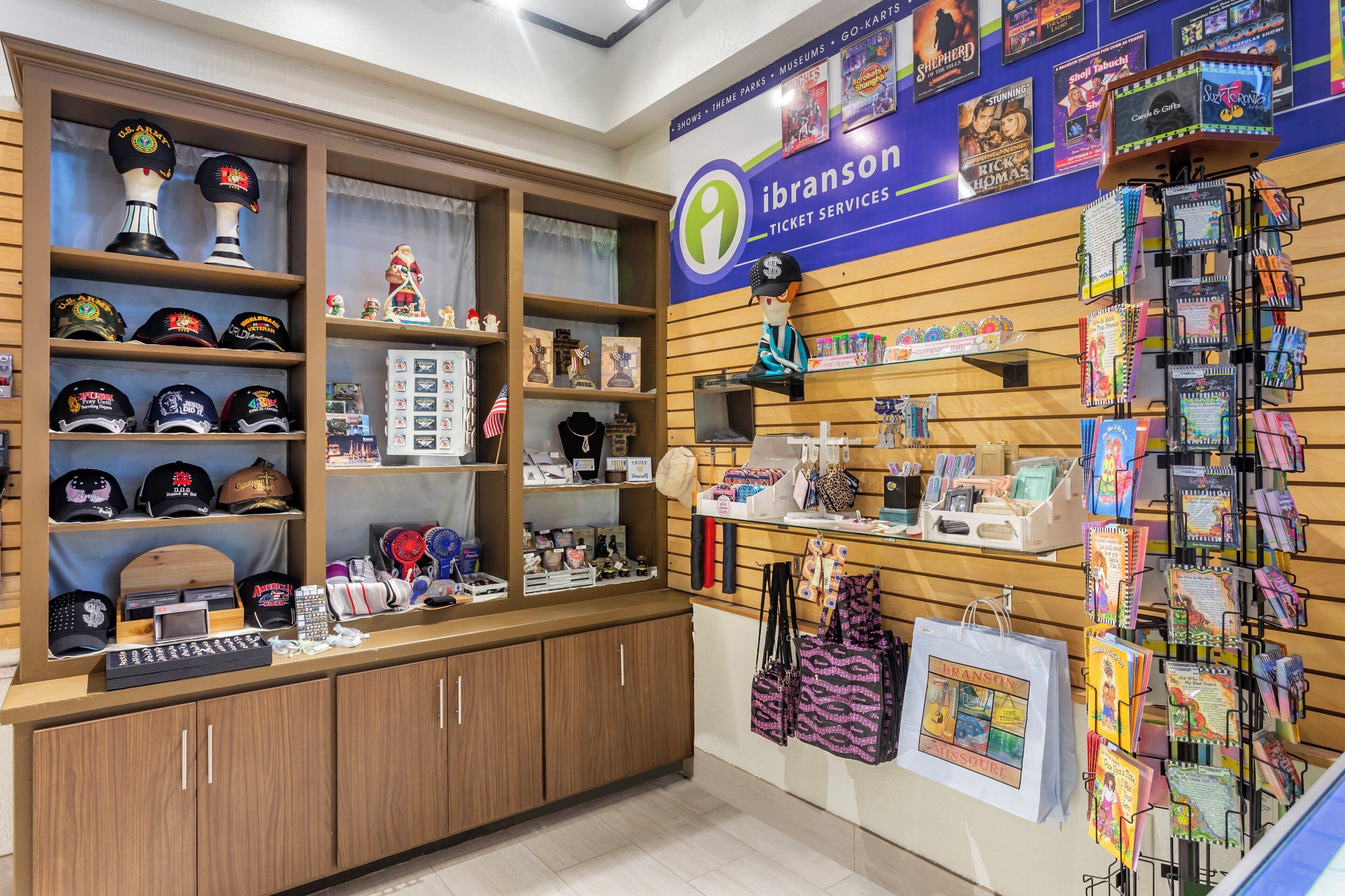 L'intérieur d'un magasin, avec des étagères remplies de chapeaux, un comptoir de vente de billets et divers articles cadeaux.