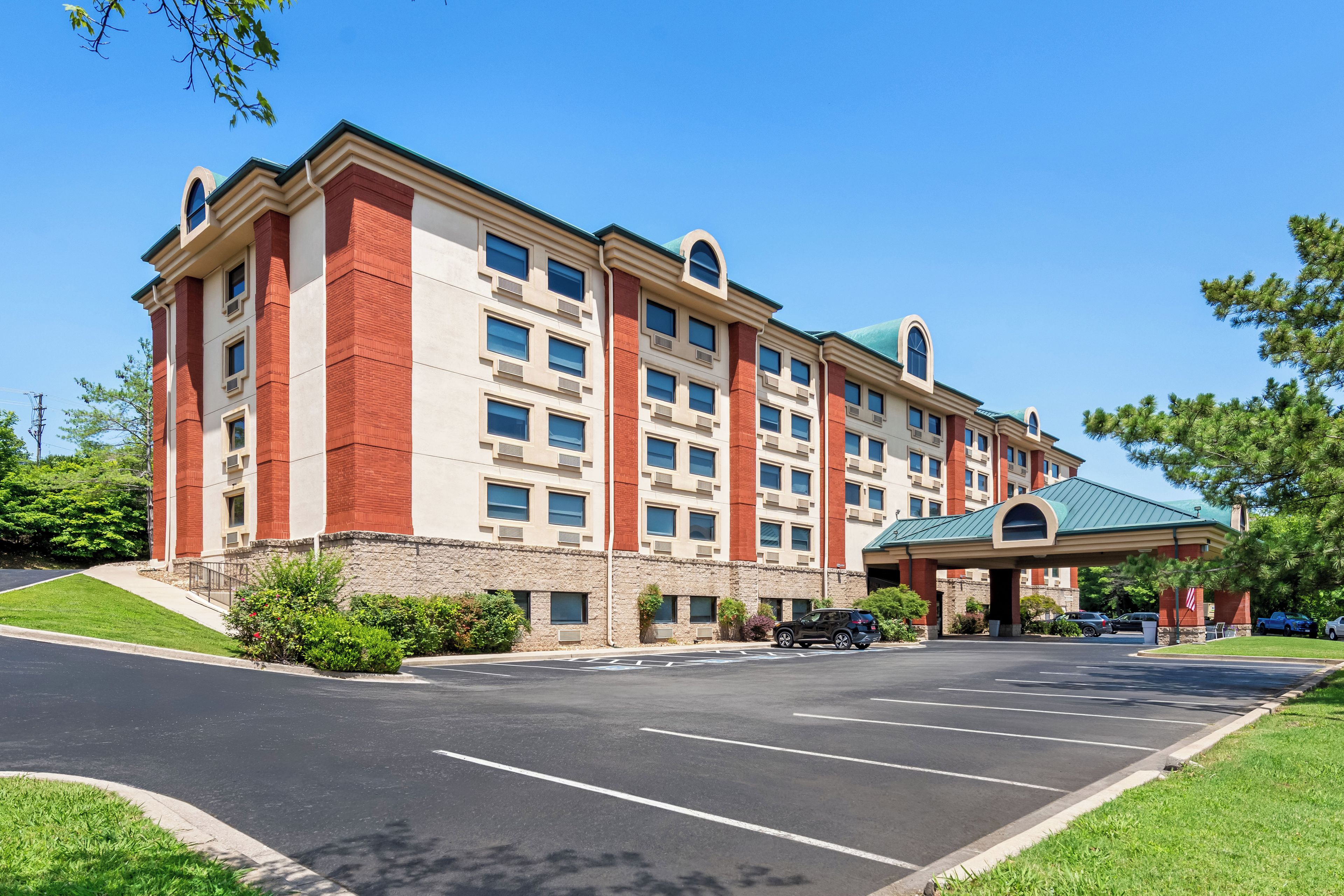 A multi-story hotel with a parking lot in front.