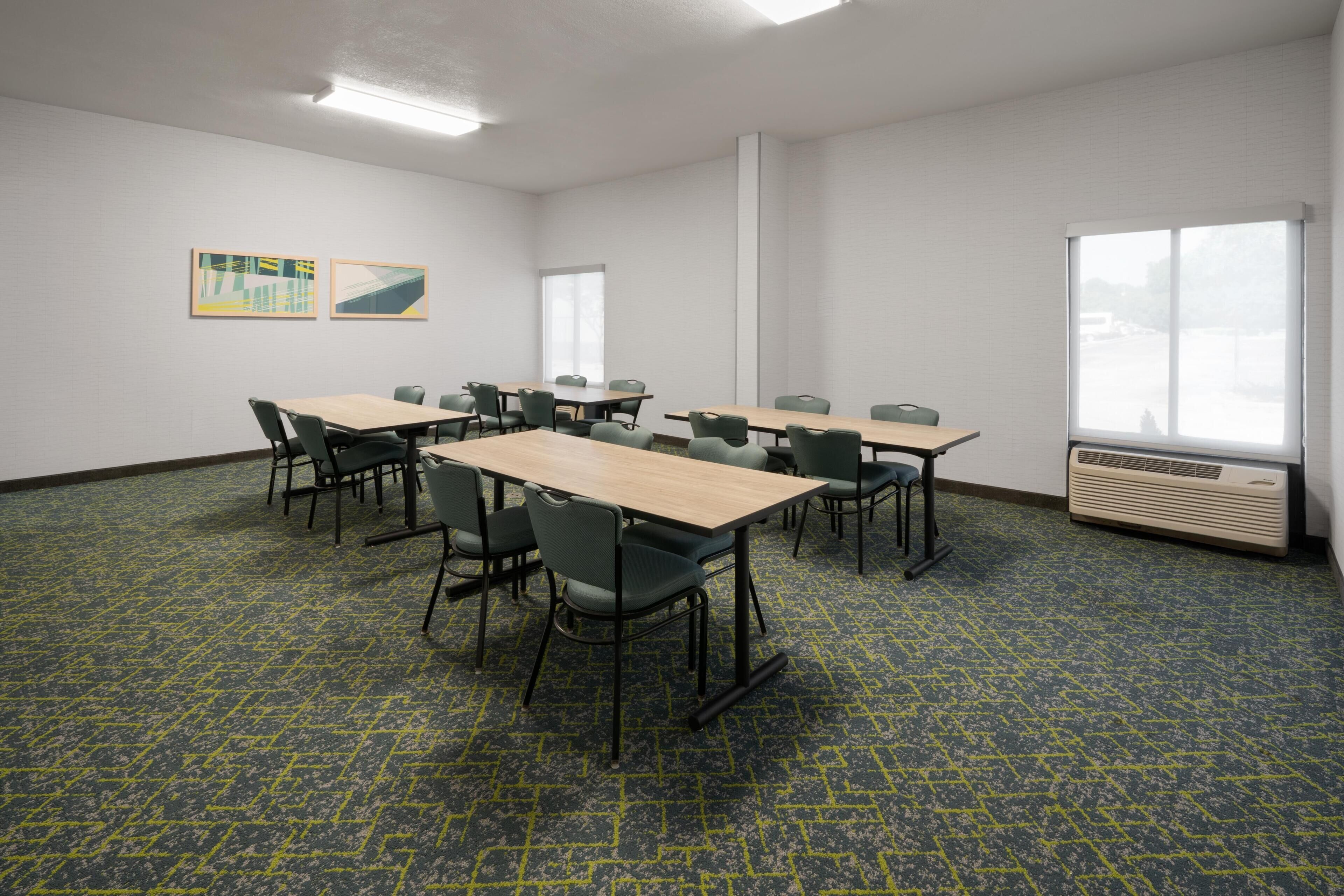 A conference room with tables and chairs, a large window, and an air conditioning unit.