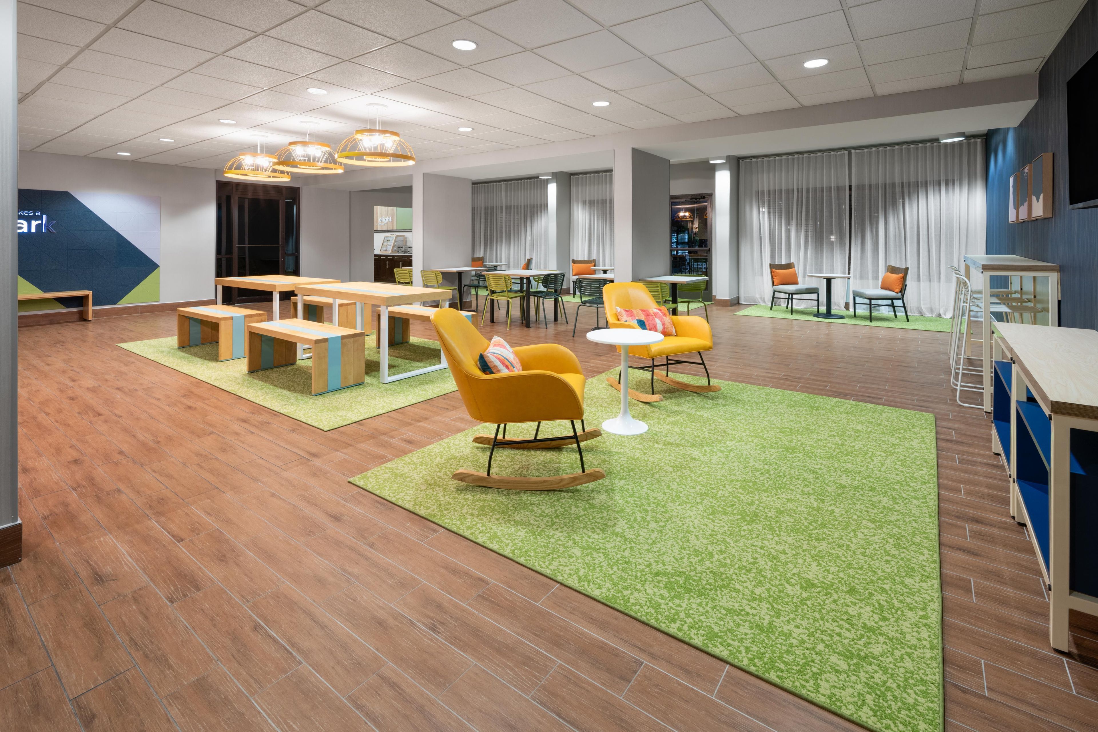A modern lounge area with seating arrangements, a bar area, and a dining space.