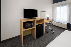 Escritorio, cortinas opacas, tabla de planchar con plancha