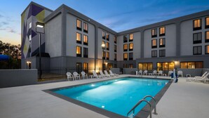 A modern hotel with a swimming pool, lounge chairs, and a geometric facade. - Spark by Hilton Decatur (Decatur)