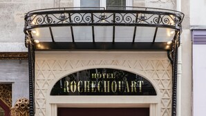 L'entrada de l'Hotel Rochechouart, amb una façana clàssica, portes dobles i il·luminació decorativa.
