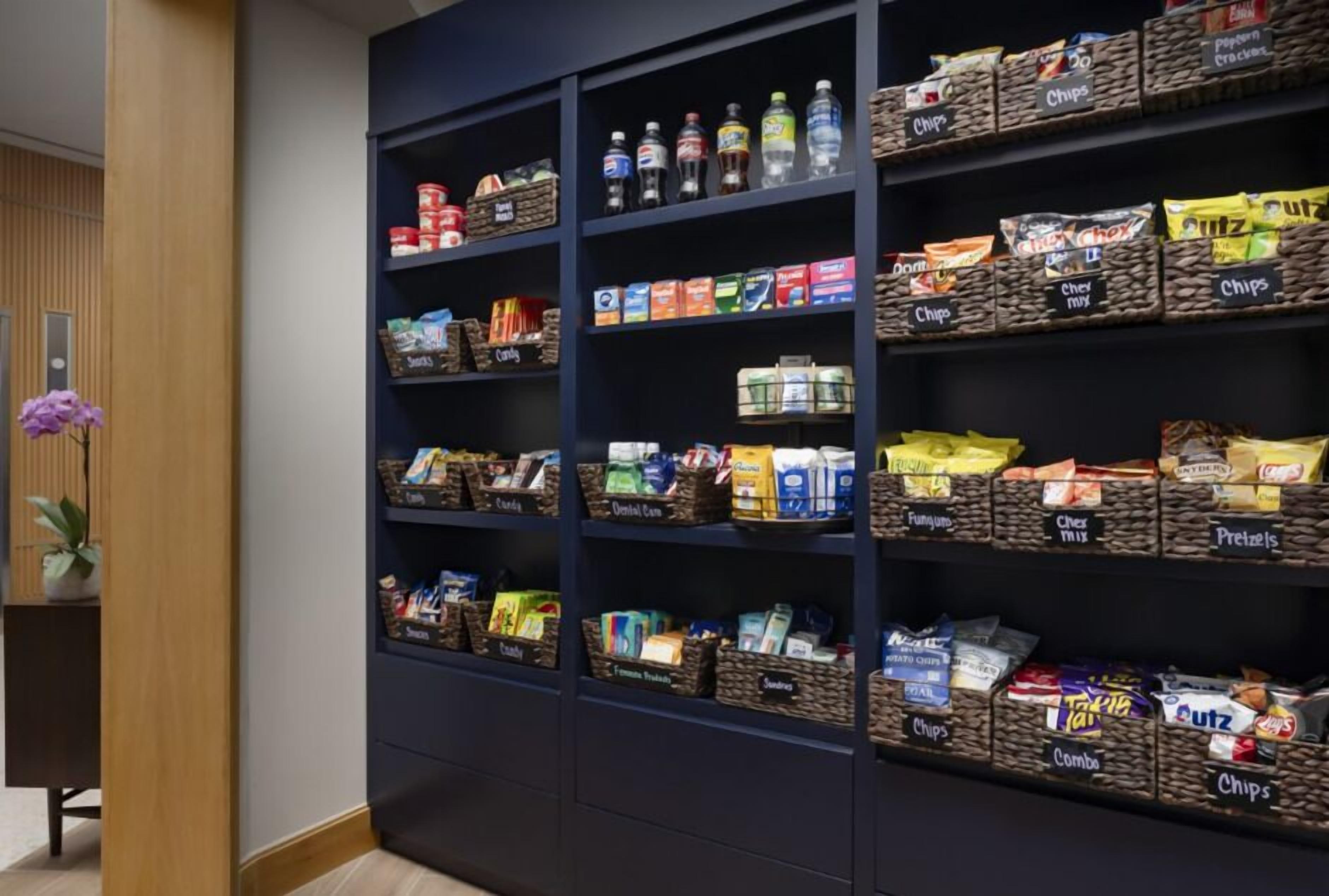A snack display with various chips, chocolates, and bottled water.