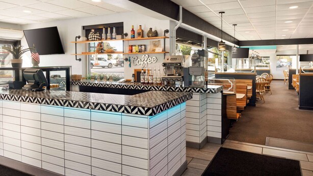 A coffee shop interior with a counter, shelves with coffee products, and seating area. - Ramada Plaza by Wyndham Portland (Portland)