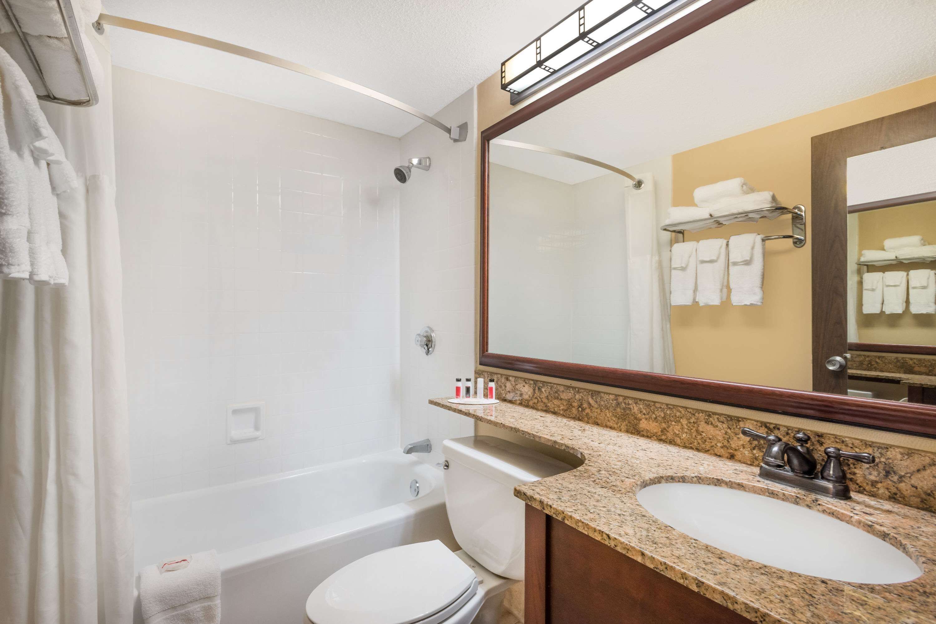 Une salle de bain avec une baignoire, des toilettes et deux lavabos.