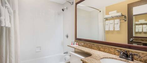Une salle de bain avec une baignoire, des toilettes et deux lavabos.