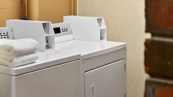 A modern laundry area with stacked towels, a washing machine, and a dryer.
