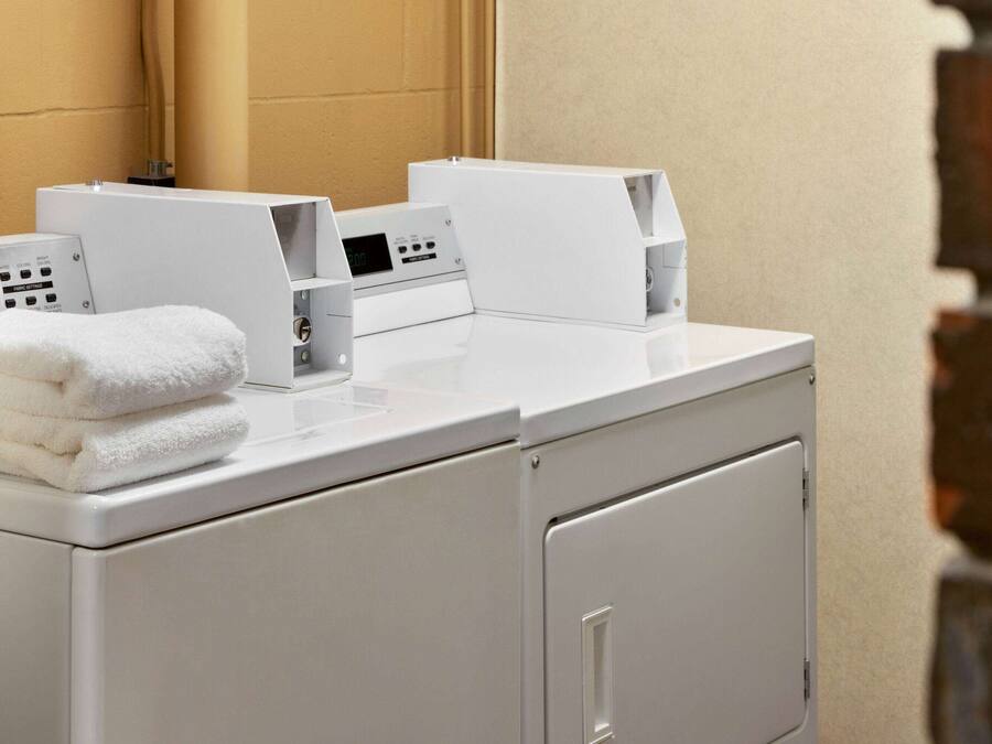 A modern laundry area with stacked towels, a washing machine, and a dryer.